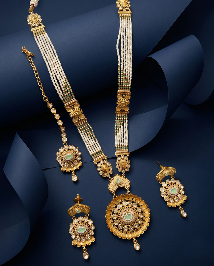 White Beaded Kundan Necklace Set with Mint Green Stone Pendant, Earrings and Maang Tikka with blue background 
