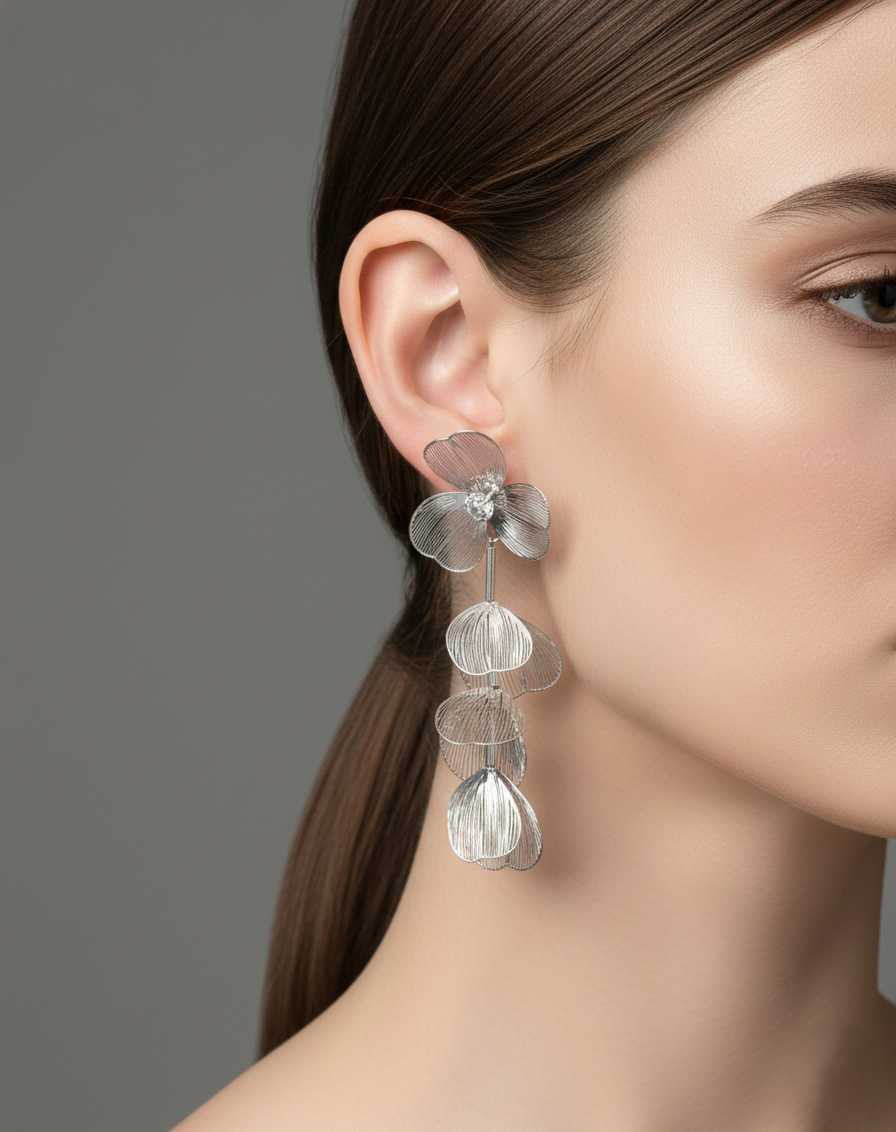 Close-up of a woman wearing a floral silver earring against a gray background
