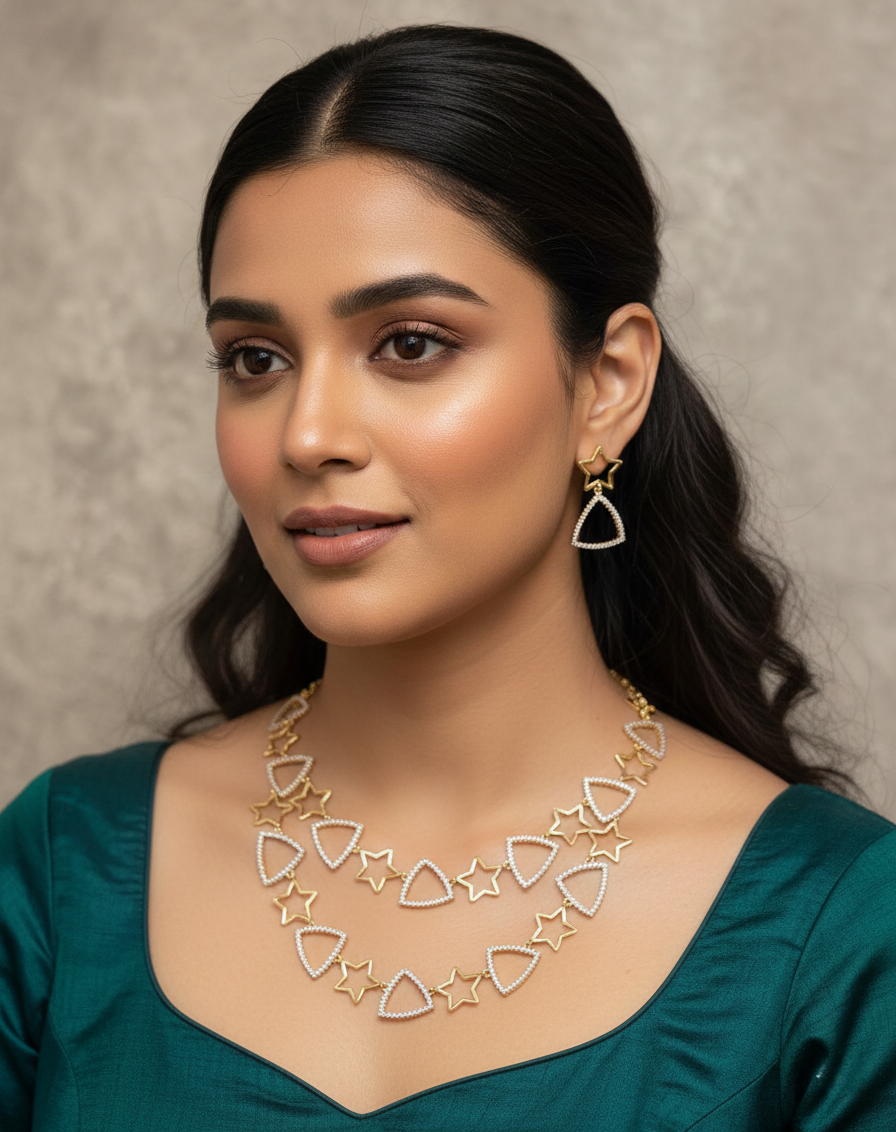 Woman wearing a gold necklace and earrings against a neutral background