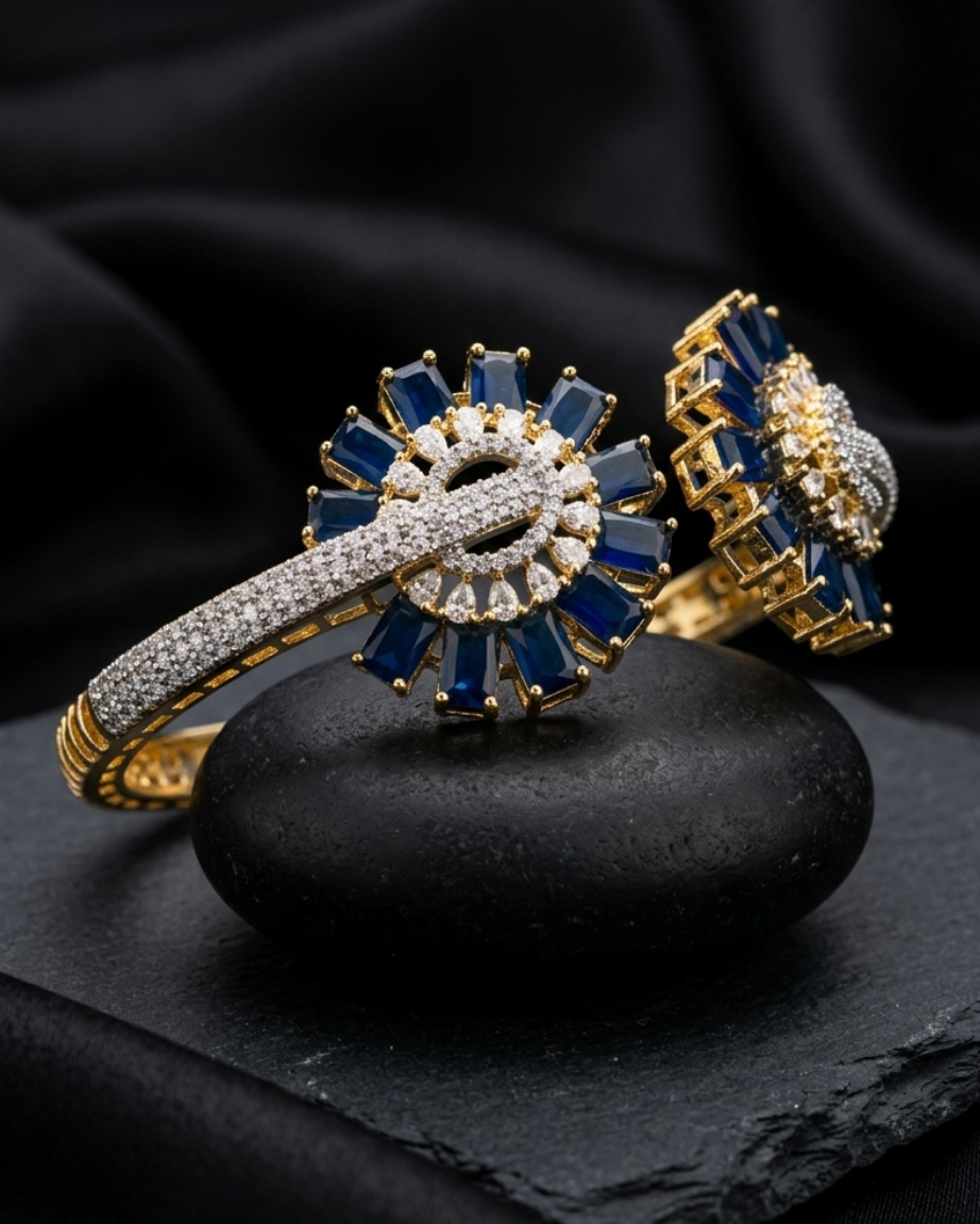 Gold and blue gemstone ring on a dark stone surface with a black fabric background