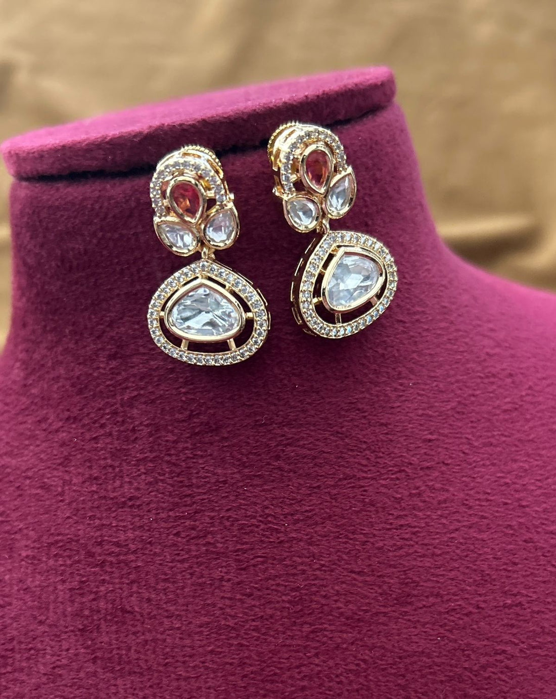 Traditional wedding necklace and earrings designed with white kundan and rich red tones