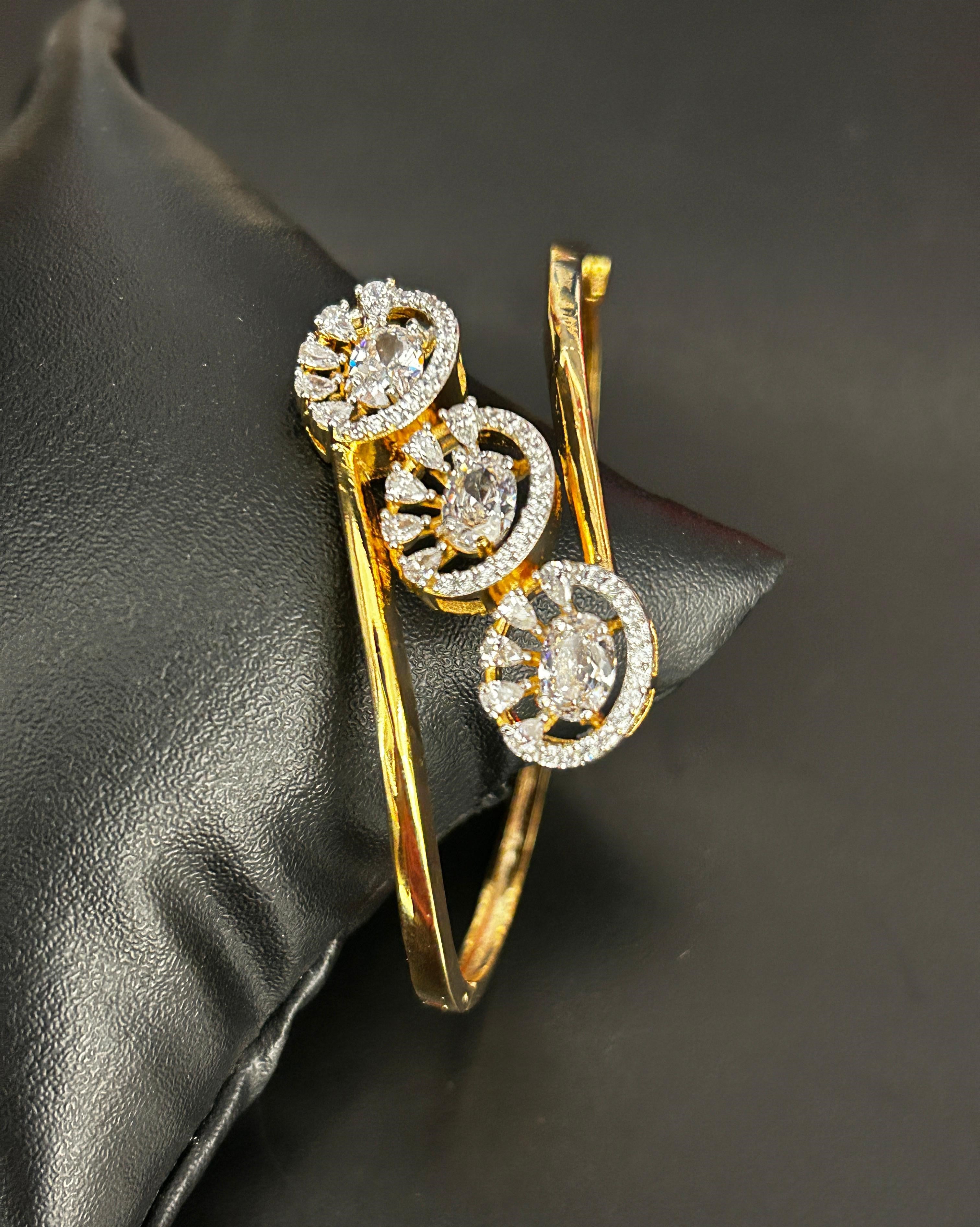 Gold and diamond bracelet on a dark fabric background