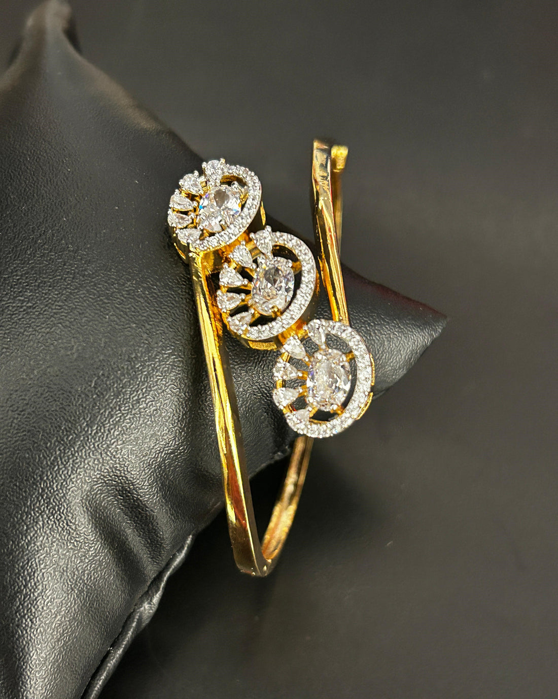 Gold and diamond bracelet on a dark fabric background