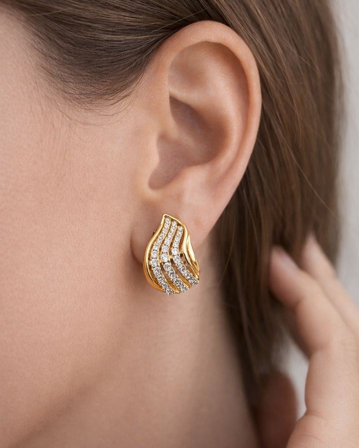 Gold and diamond earring worn by a person
