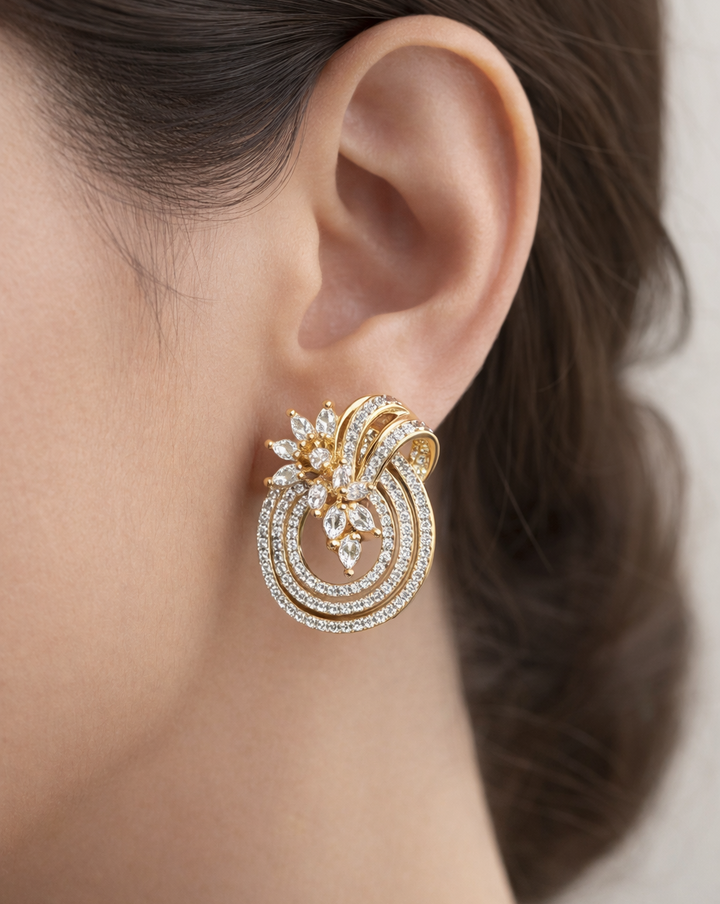 Gold and diamond earring worn by a person with a neutral background