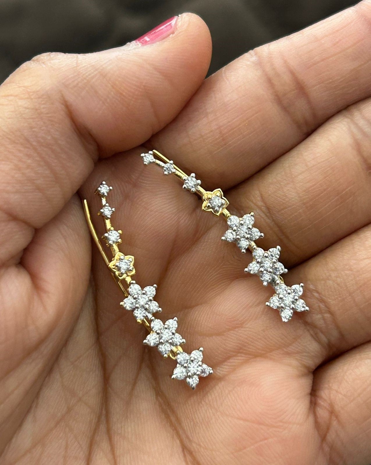 Gold and diamond earrings held 