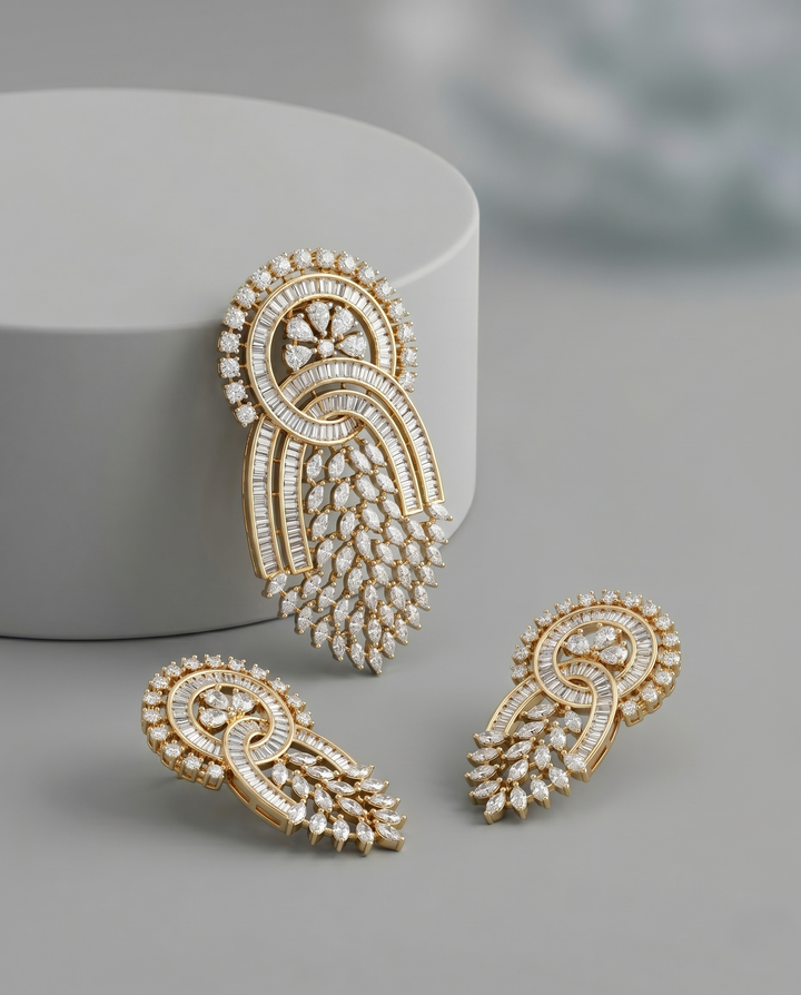 Gold and diamond earrings on a gray surface with a white container.