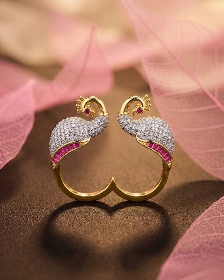 Gold and diamond earrings with red gemstones on a pink fabric background