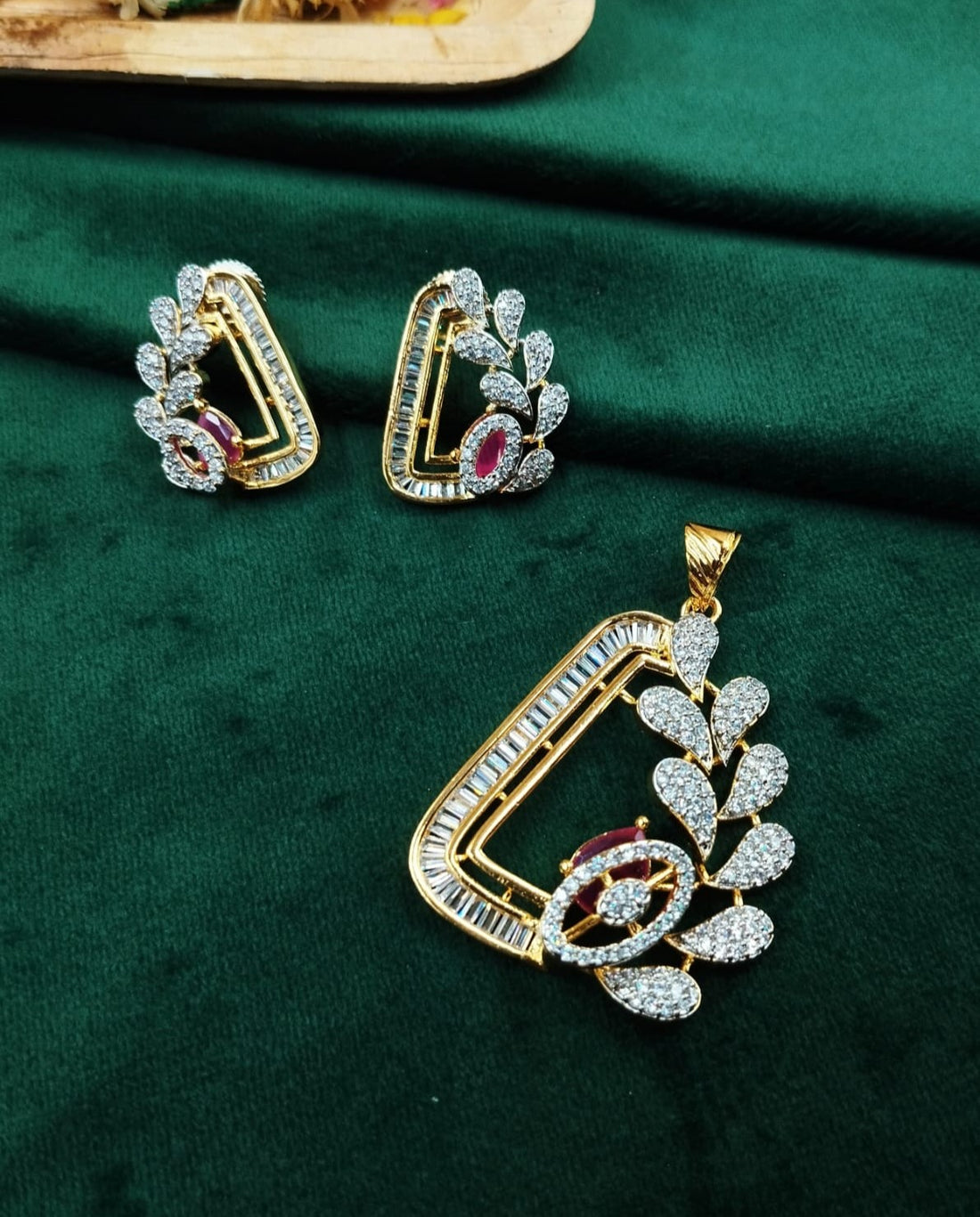 Gold and diamond jewelry set on a green fabric background