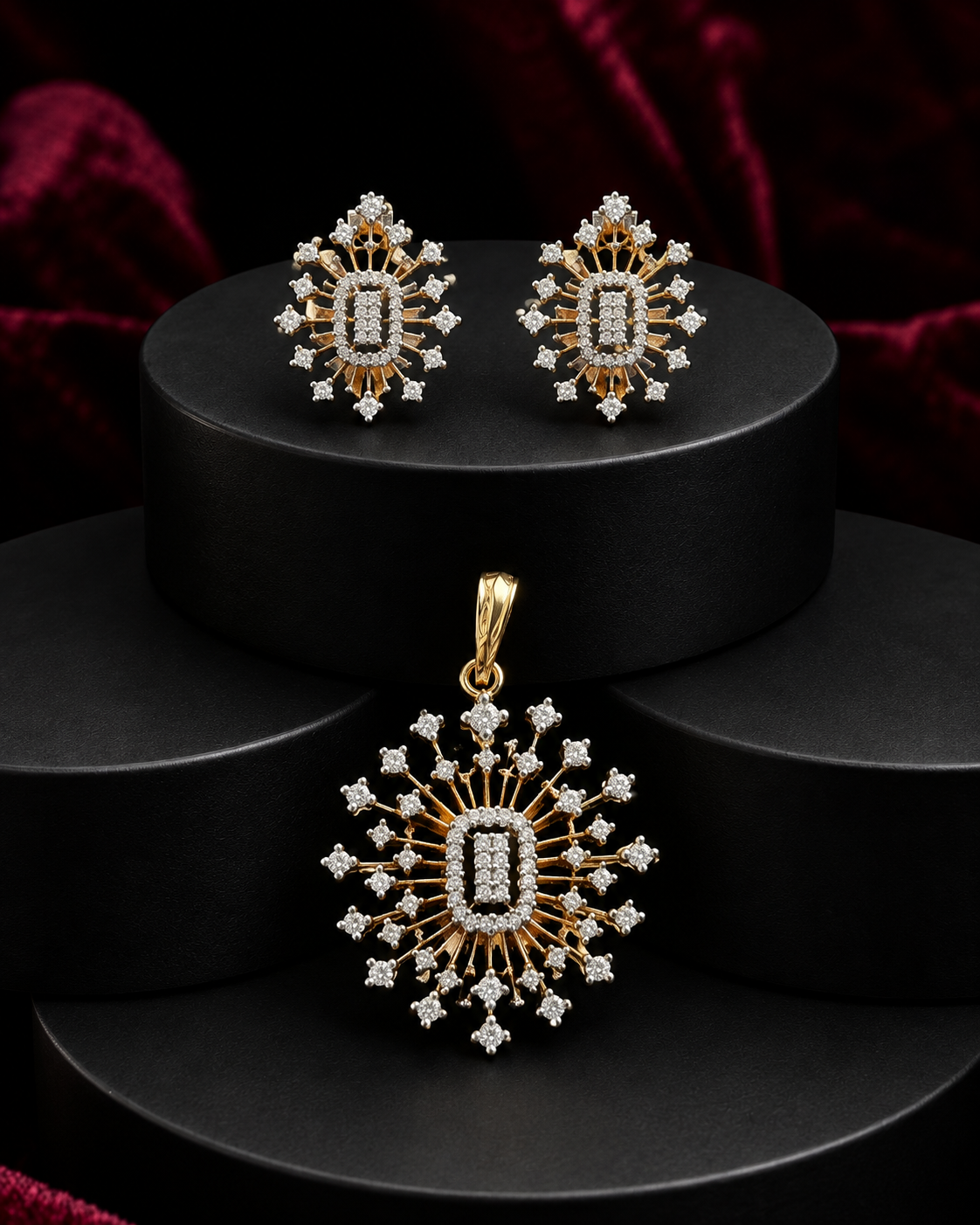 Gold and diamond jewelry set featuring a matching pendant and stud earrings with a central rectangular diamond surrounded by radiating diamond clusters, displayed on black cylindrical pedestals.