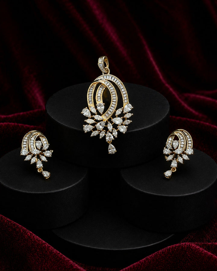 Gold and diamond jewelry set featuring a pendant, earrings, and matching rings displayed on black cylindrical pedestals against a dark red velvet background.