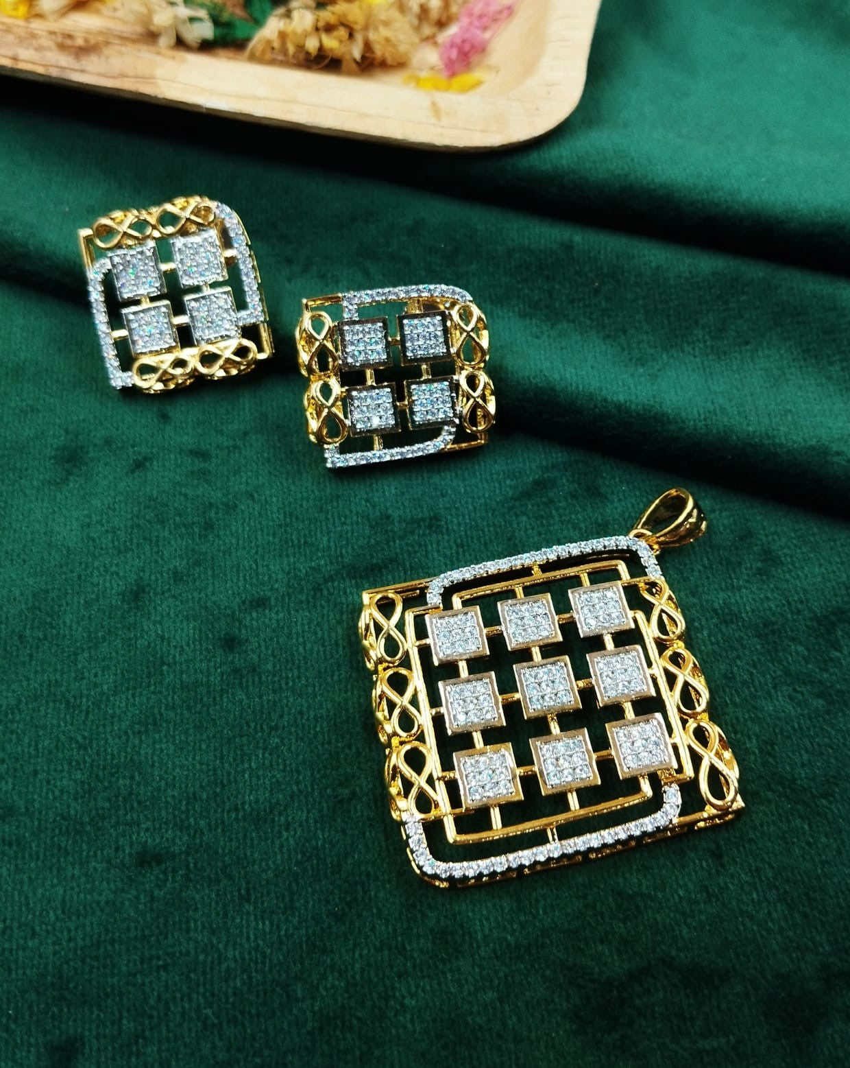 Gold and diamond jewelry set on a green fabric background