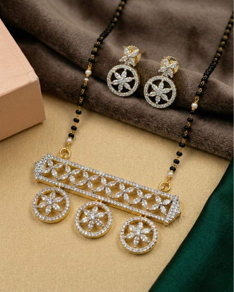 Gold and diamond necklace with matching earrings on a brown fabric background