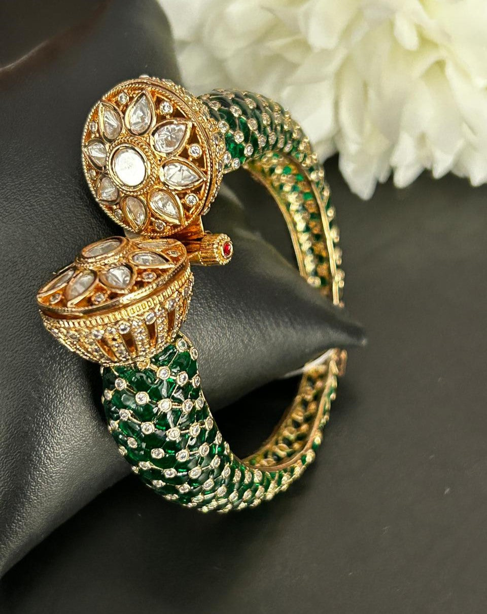 Gold and green bracelet with intricate design on a dark surface