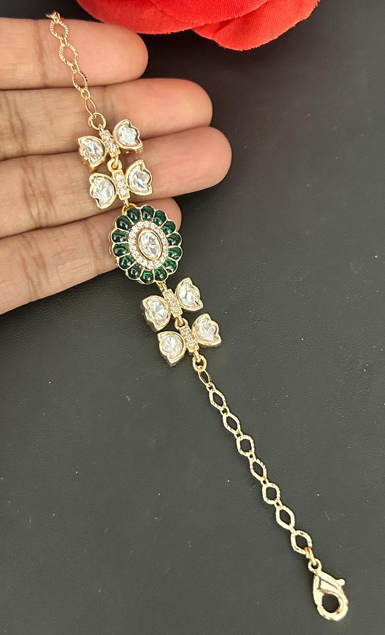 Gold and green decorative hairpin held by a hand on a dark background