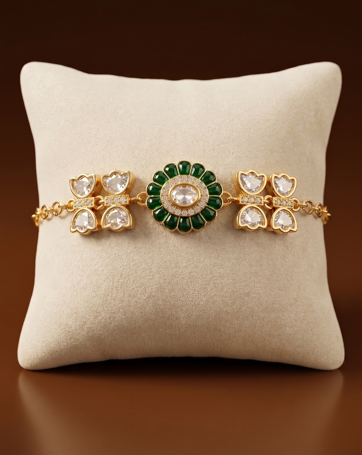 Gold and green gemstone bracelet on a beige cushion with a brown background