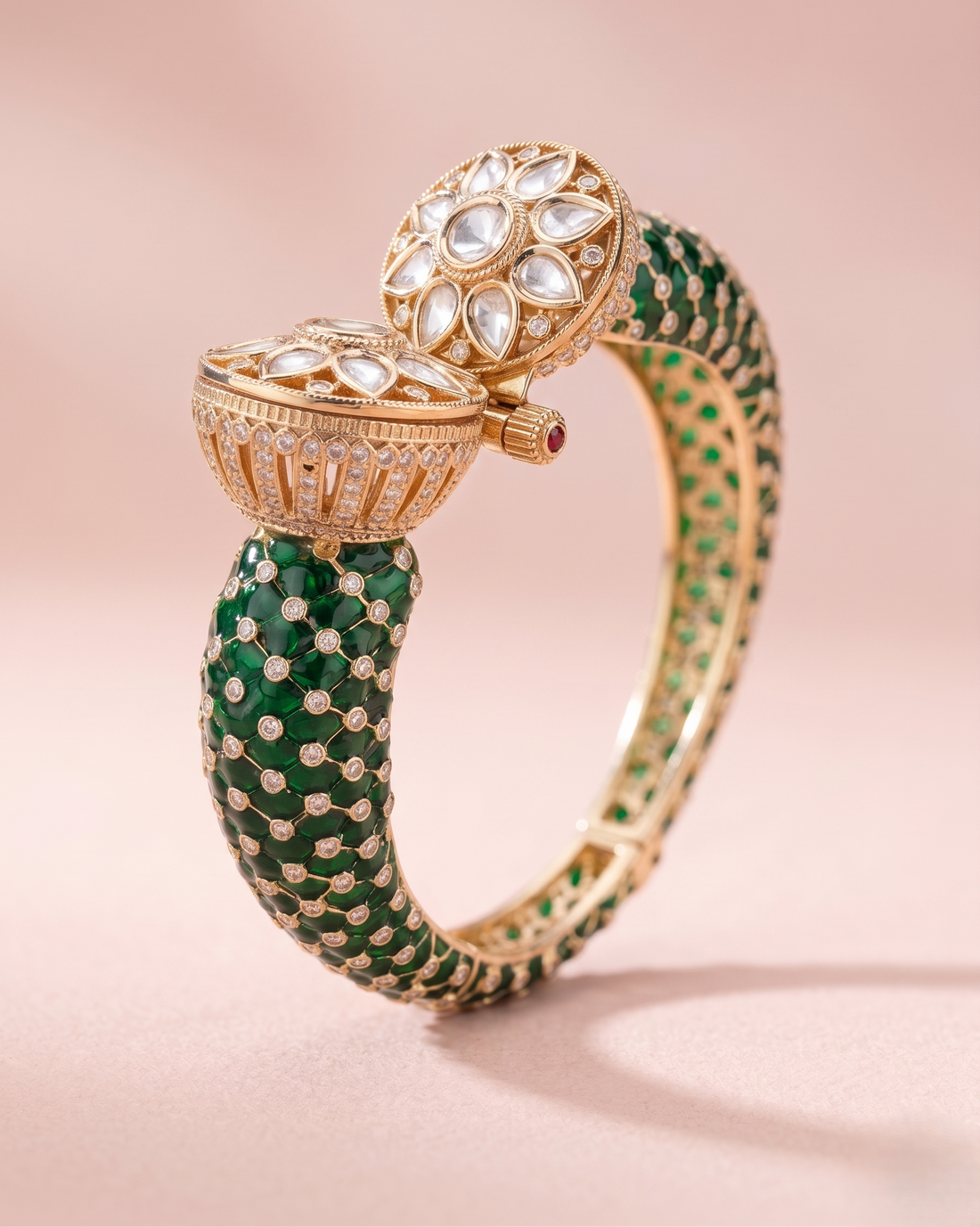 Gold and green gemstone bracelet on a pink background