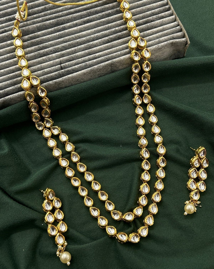 Traditional kundan jewellery ensemble featuring twin-row necklace and pearl accents