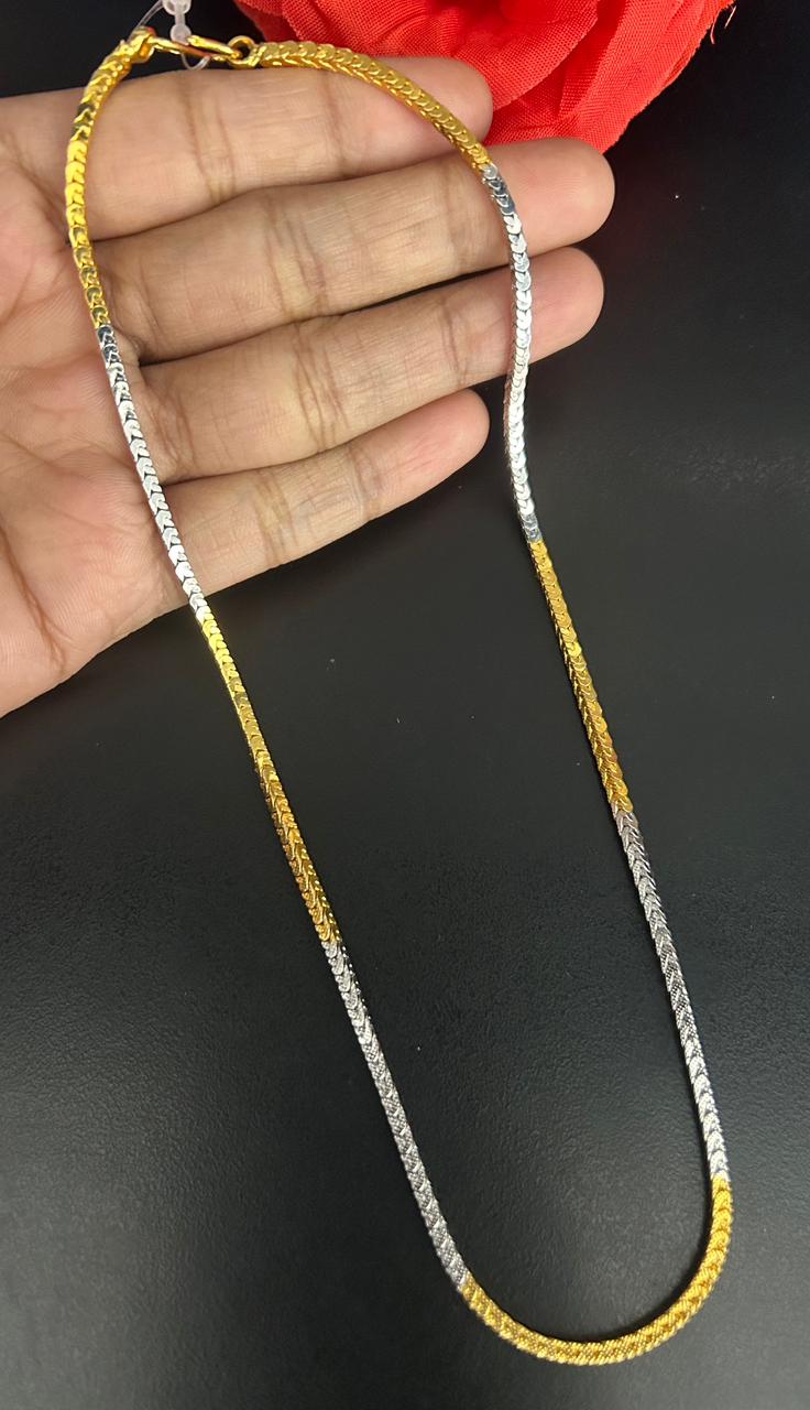Gold and silver chain held by a hand on a black background