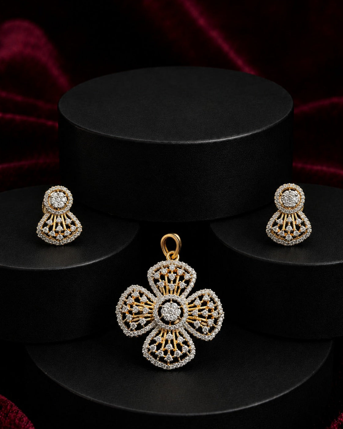 Gold and white stone jewelry set featuring a four-petal pendant, matching stud earrings, and a black cylindrical display stand on a dark red velvet background.