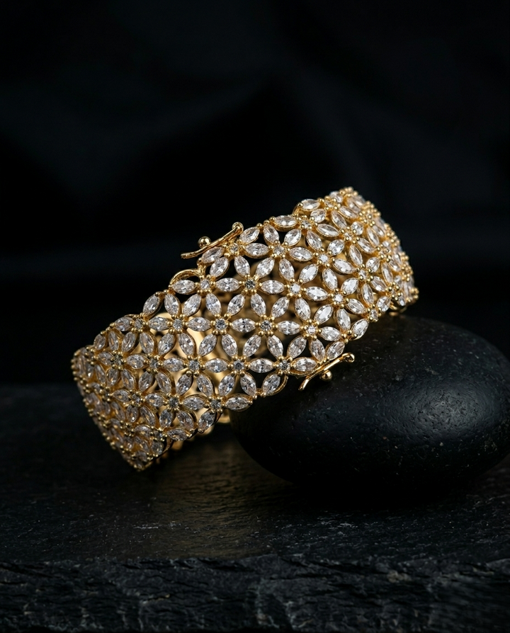 Gold bracelet with clear stones on a dark background