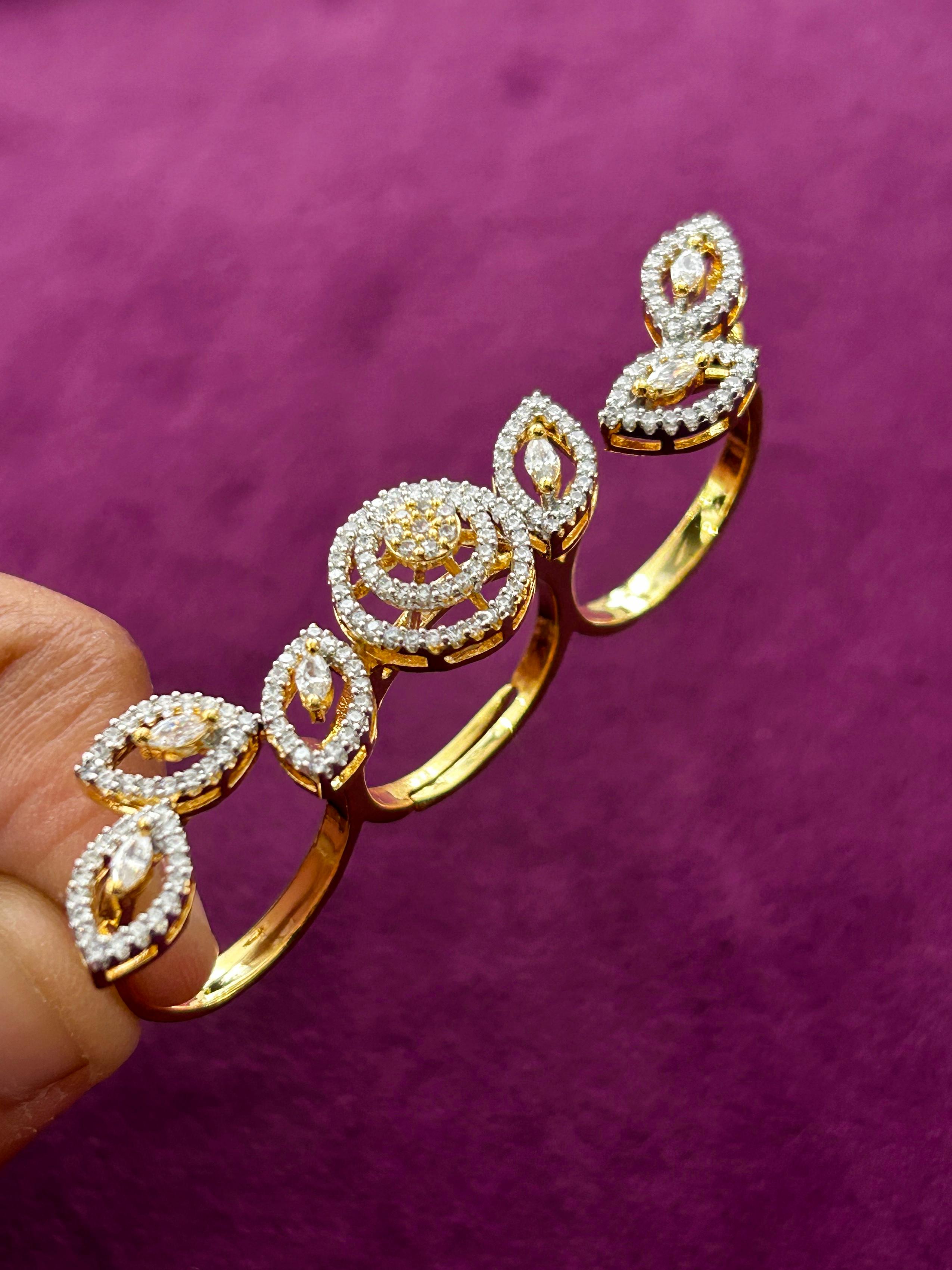 Gold bracelet with diamond accents held by a hand against a purple background