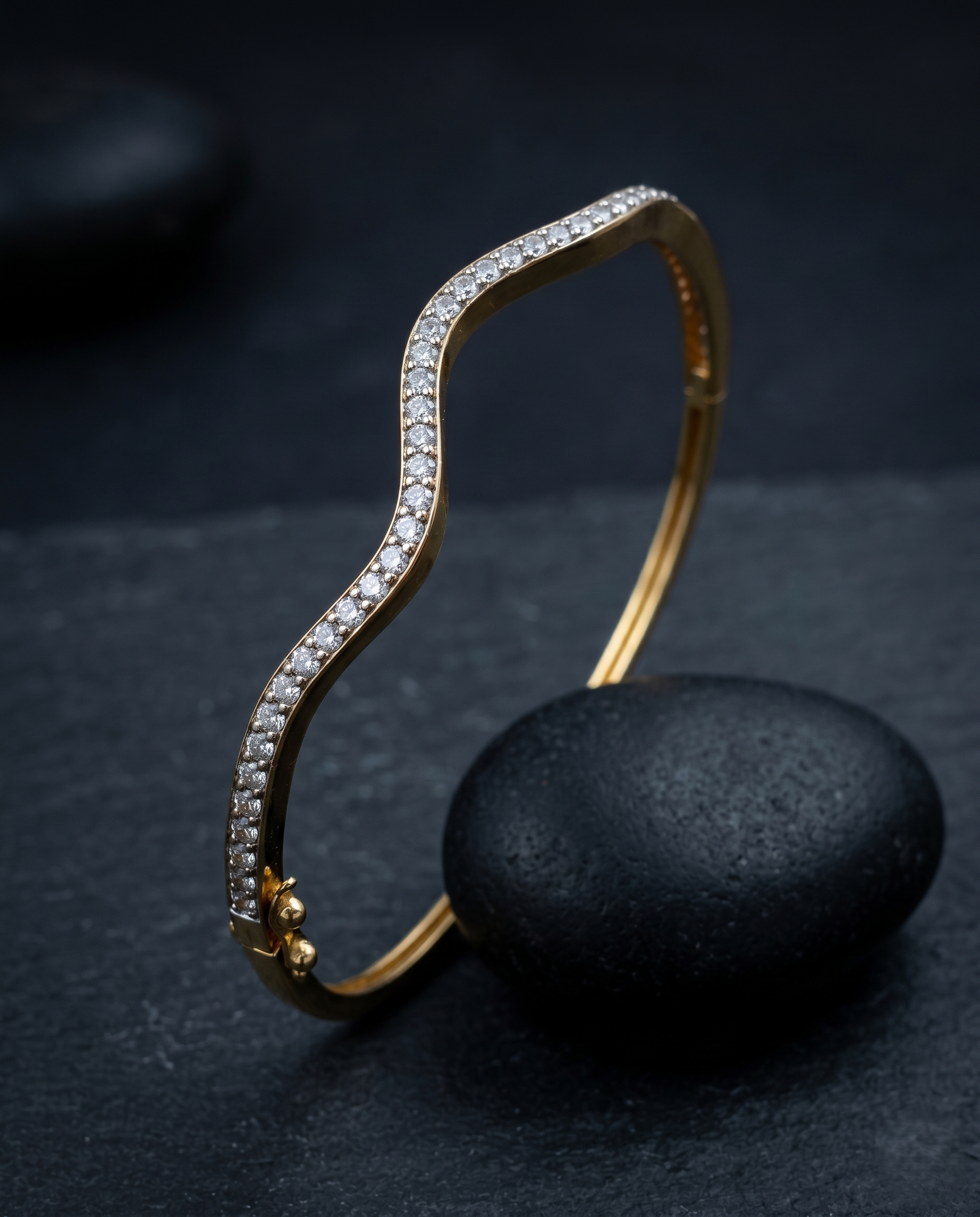 Gold bracelet with diamond accents on a dark stone surface