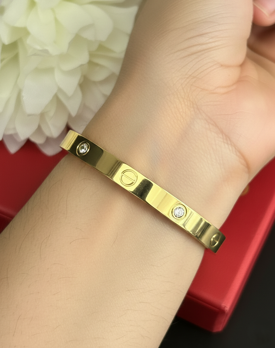 Gold bracelet with diamonds on a wrist against a white flower background
