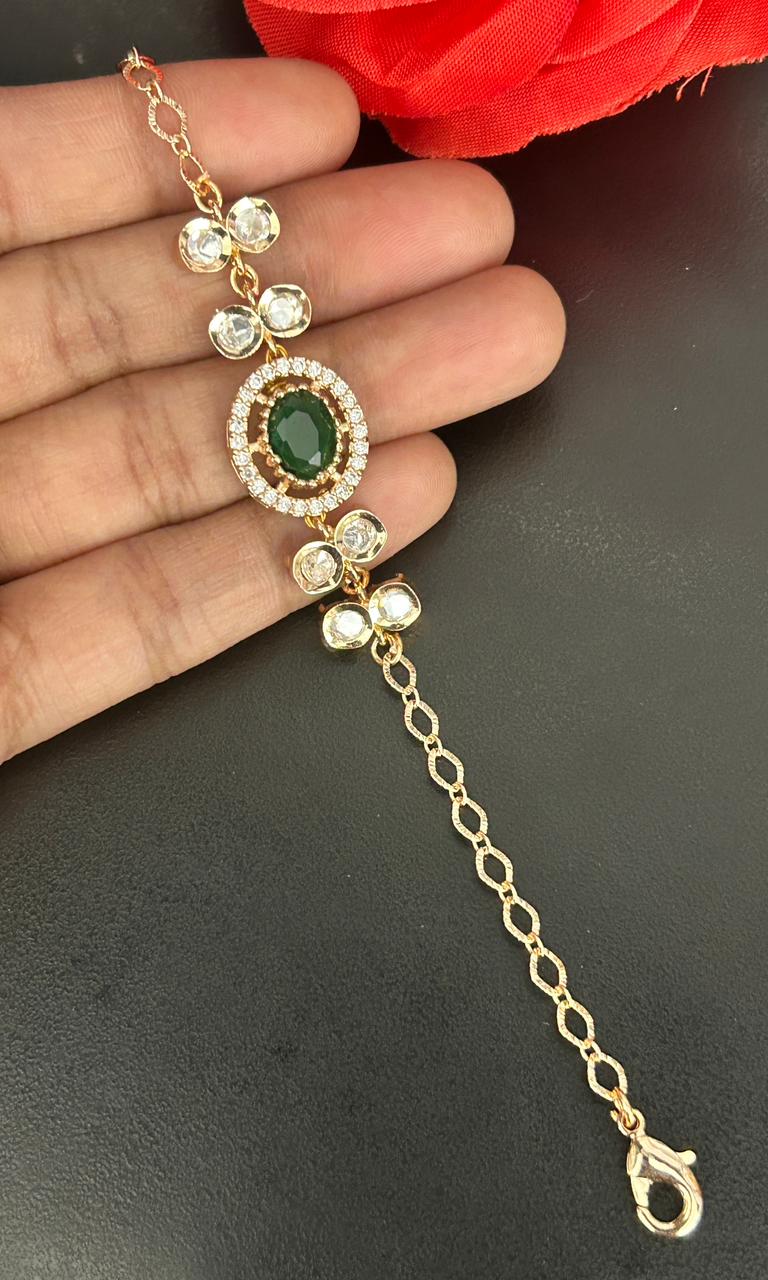 Gold bracelet with green gemstone on a hand against a dark background