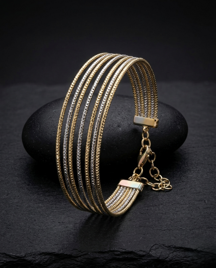 Gold bracelet with multiple chains on a dark stone surface