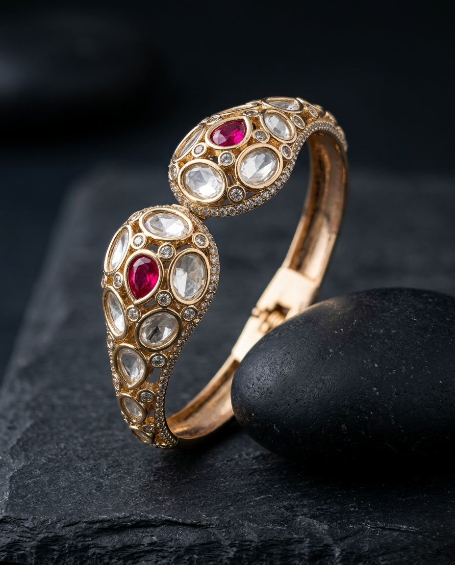 Gold bracelet with red and clear gemstones on a dark stone surface