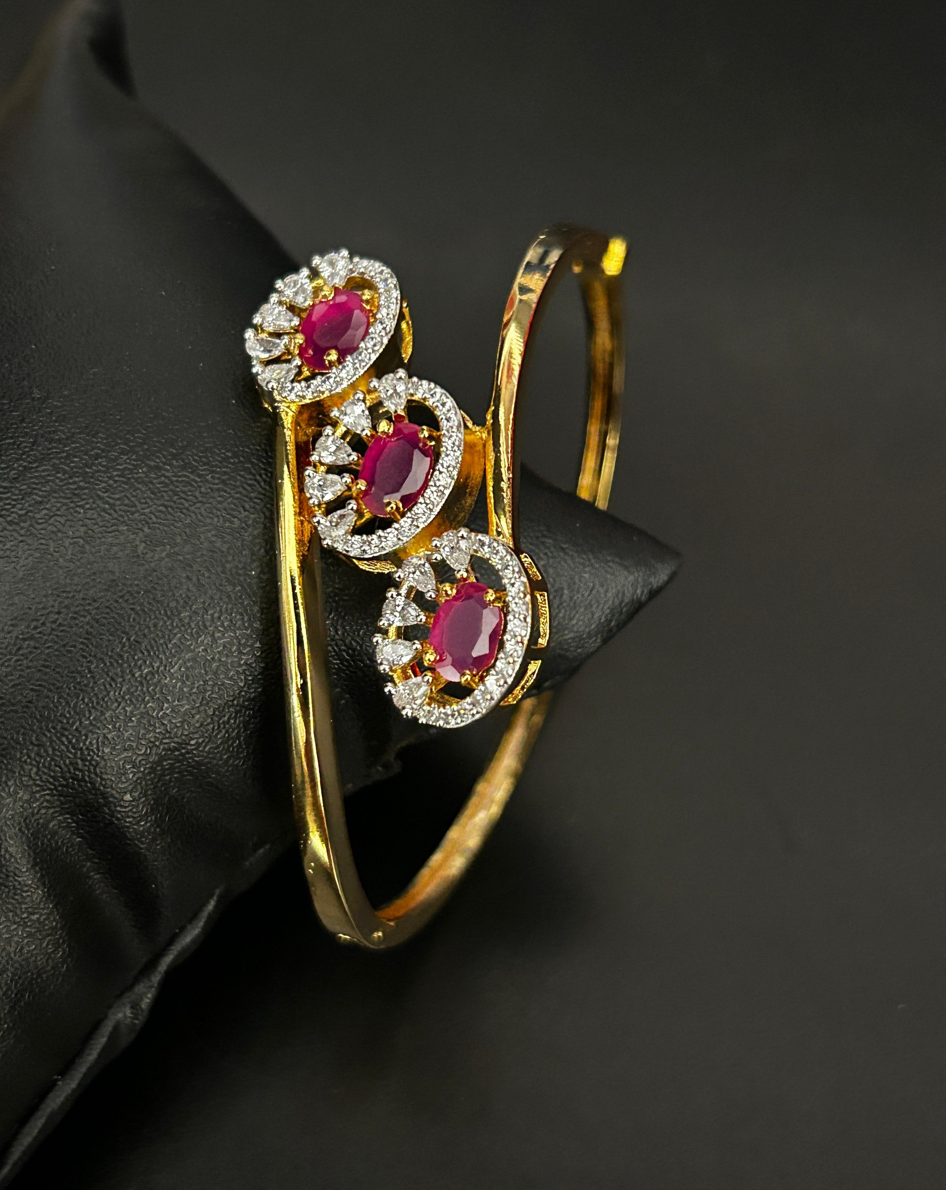 Gold bracelet with red gemstones on a black background
