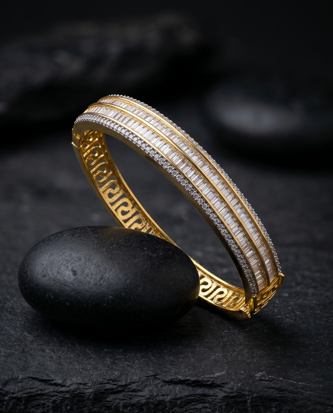 Gold bracelet with white stones on a dark stone surface