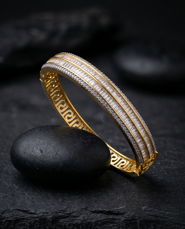 Gold bracelet with white stones on a dark stone surface