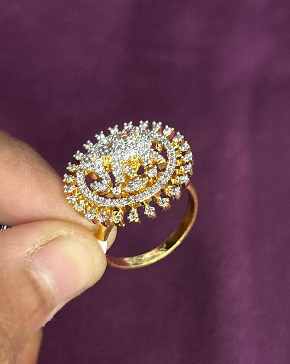 Gold and diamond ring held by a hand against a purple background