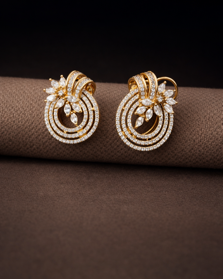 Gold earrings with diamond accents on a brown surface