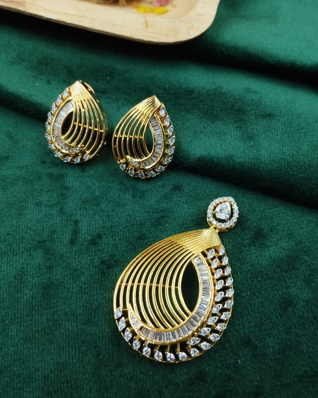 Designer gold toned teardrop pendant set featuring layered diamond look detailing, elegant jewellery for sale