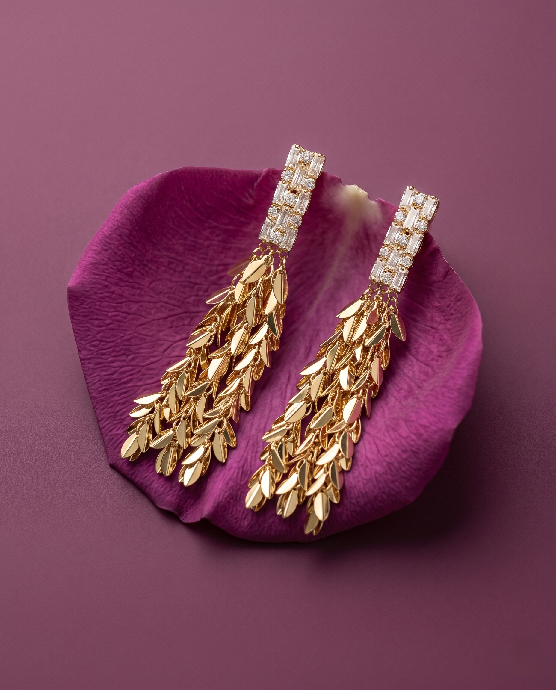 Gold earrings with diamond accents on a purple petal