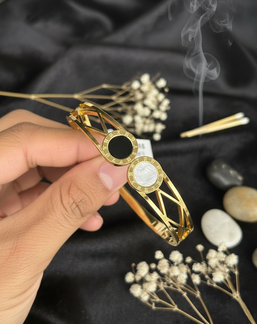 Gold fidget spinner held by a hand with a black background and decorative elements.