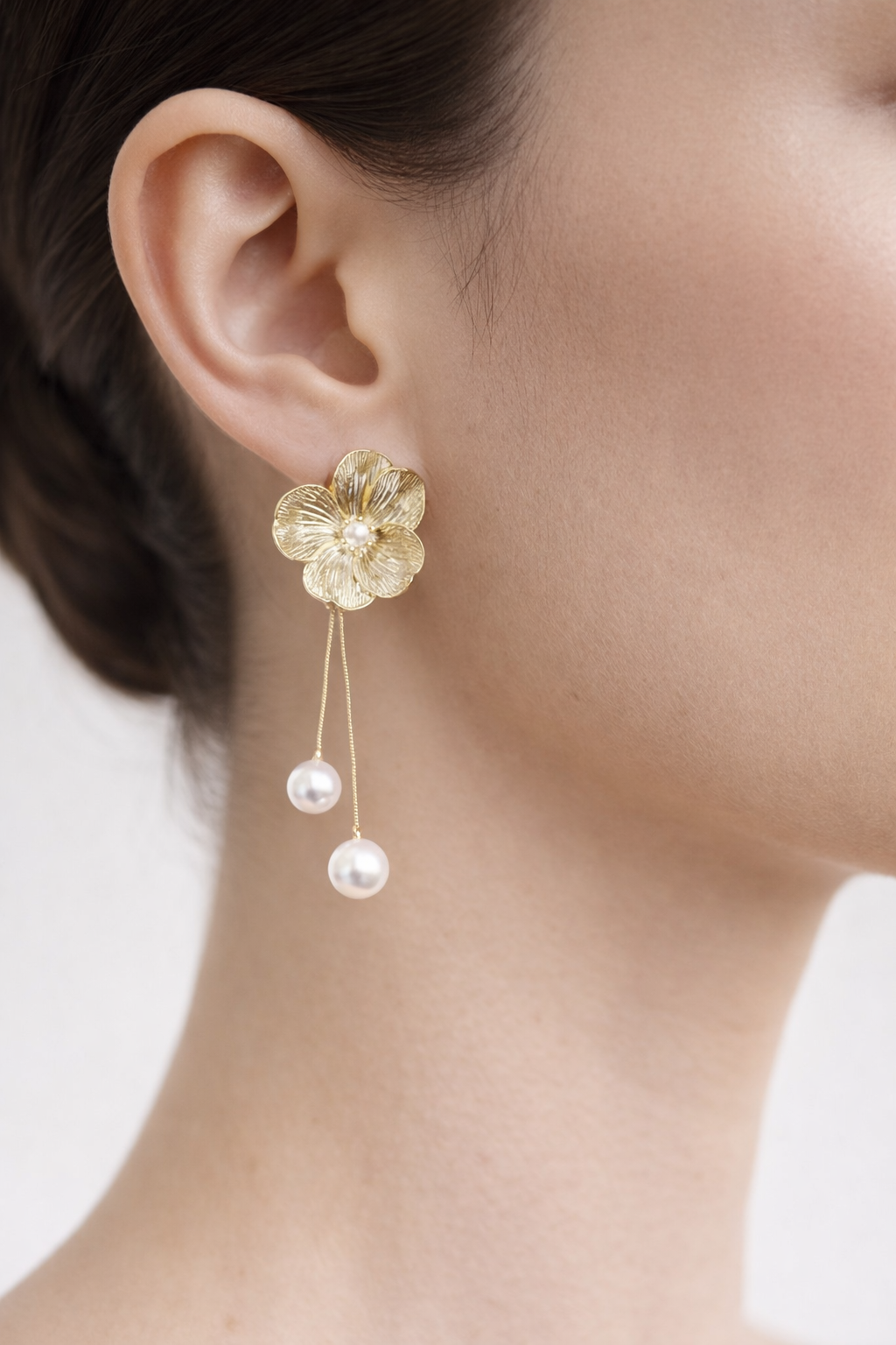 Stylish floral pearl drop earrings with white pearls and gold finish, perfect for festive wear