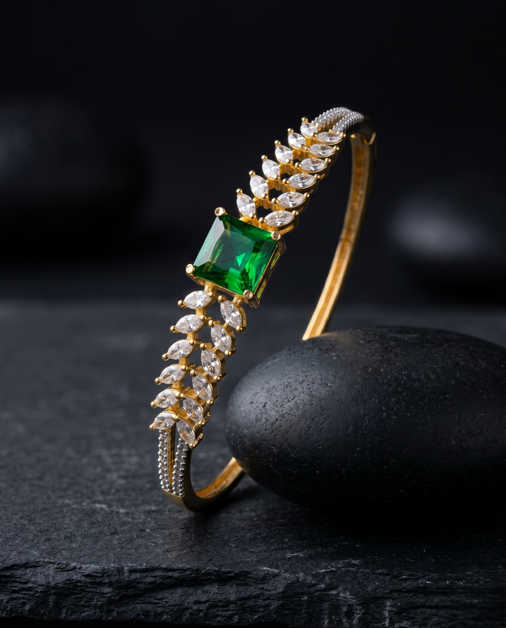 Gold headband with green gemstone and white stones on a dark surface