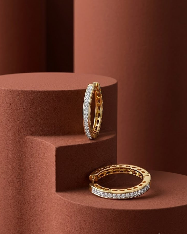 Gold hoop earrings with diamond accents on a brown geometric platform