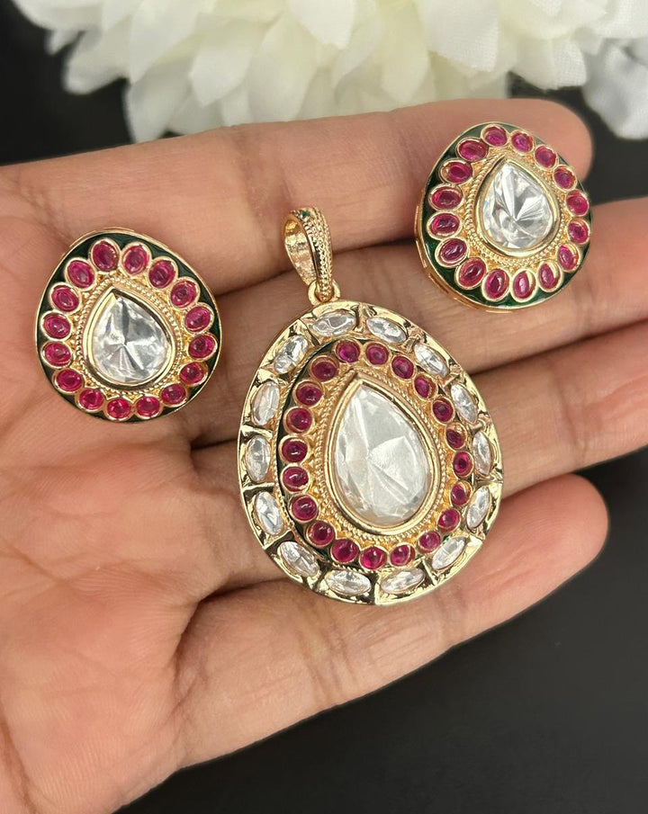 Gold jewelry set with teardrop-shaped gemstones on a hand