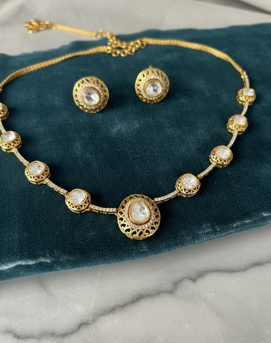 Gold necklace and earrings on a blue velvet cushion