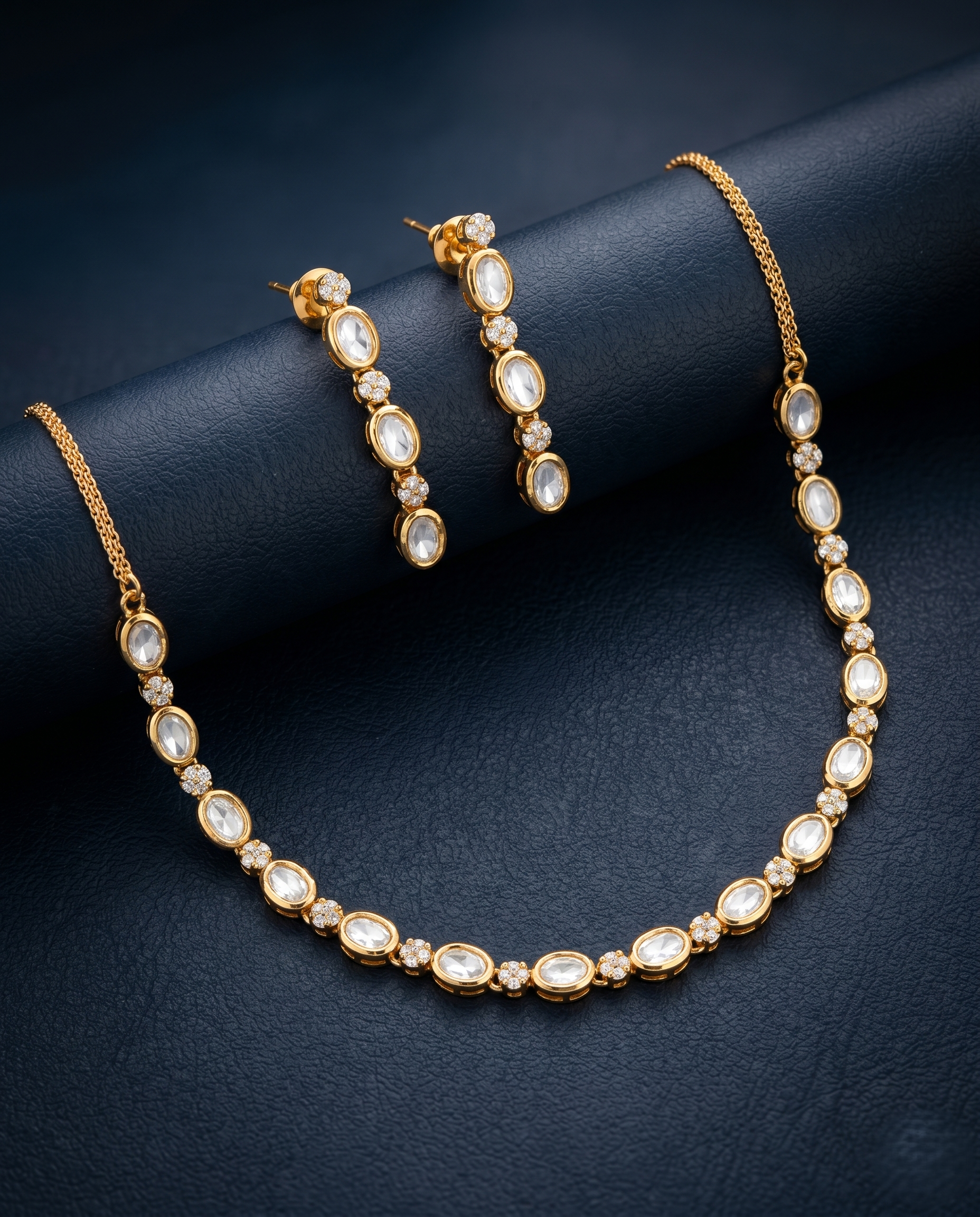 Gold necklace and earrings on a dark blue background