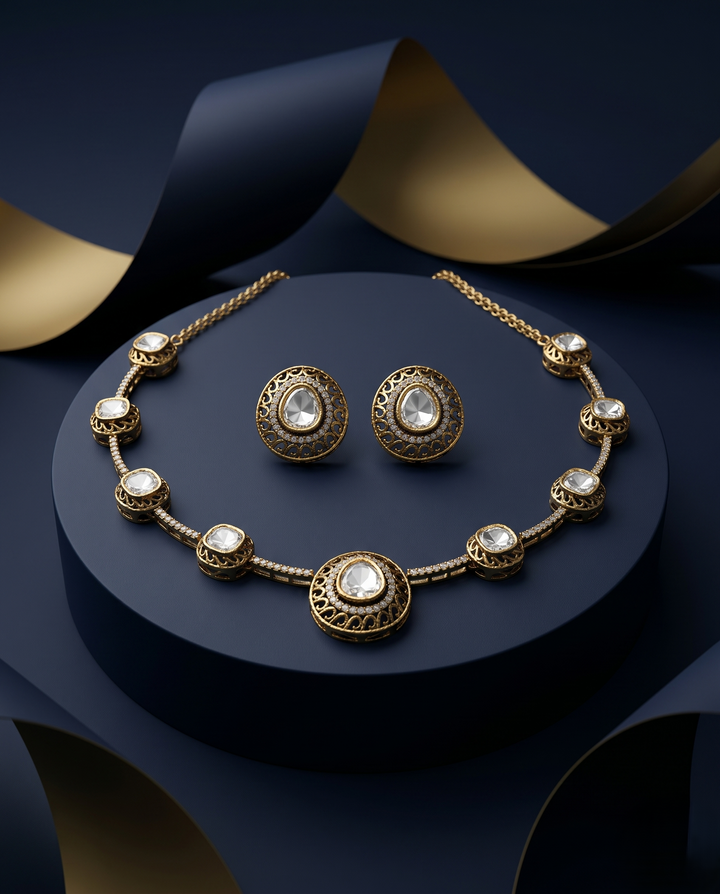 Gold necklace and earrings on a hand with a navy blue box in the background
