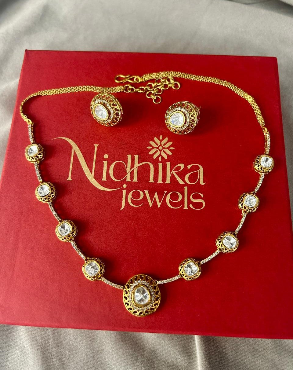 Gold necklace and earrings on a red Nidhika Jewels box