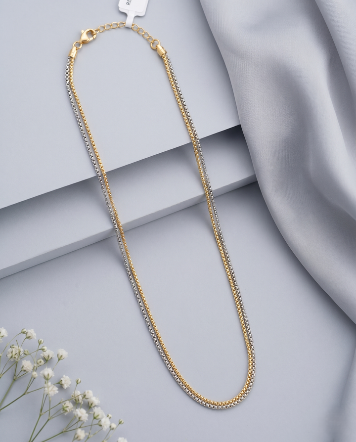 Gold necklace on a gray surface with a soft fabric background
