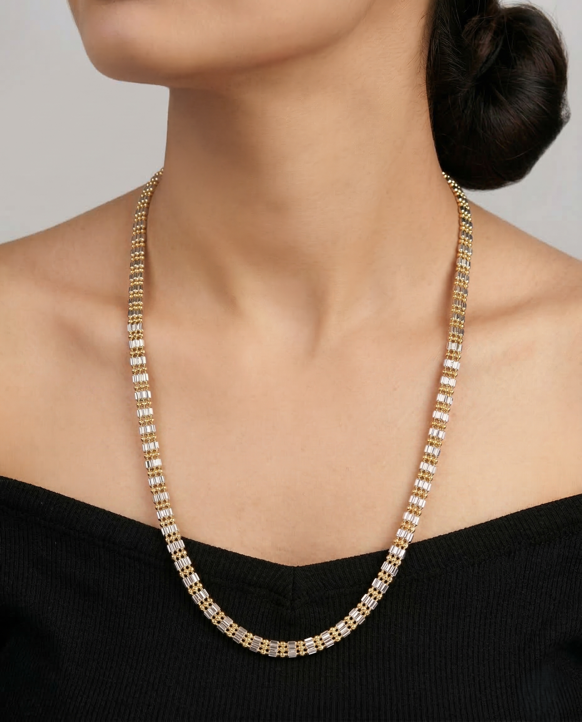 Gold necklace on a model against a neutral background