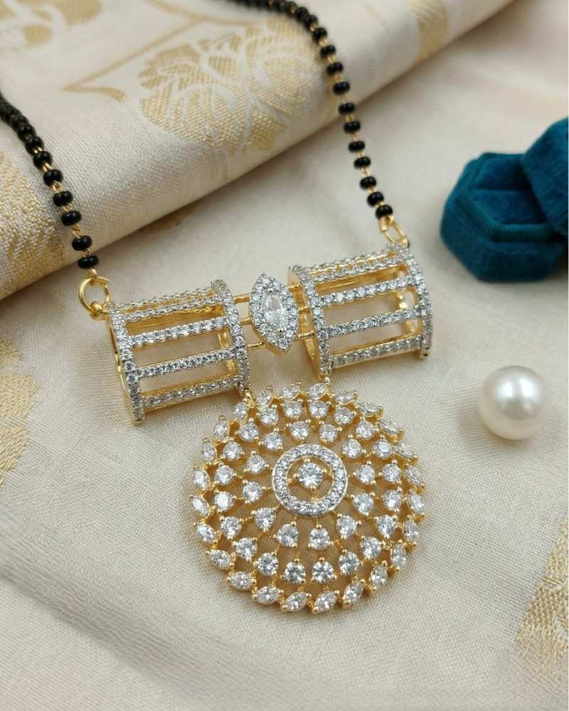 Gold necklace with a large pendant on a textured fabric background